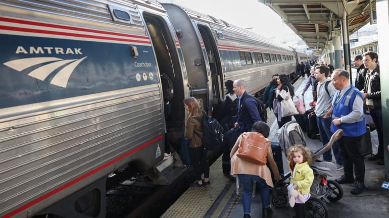 Travelers board an Amtrak train at Union Station in Washington,...