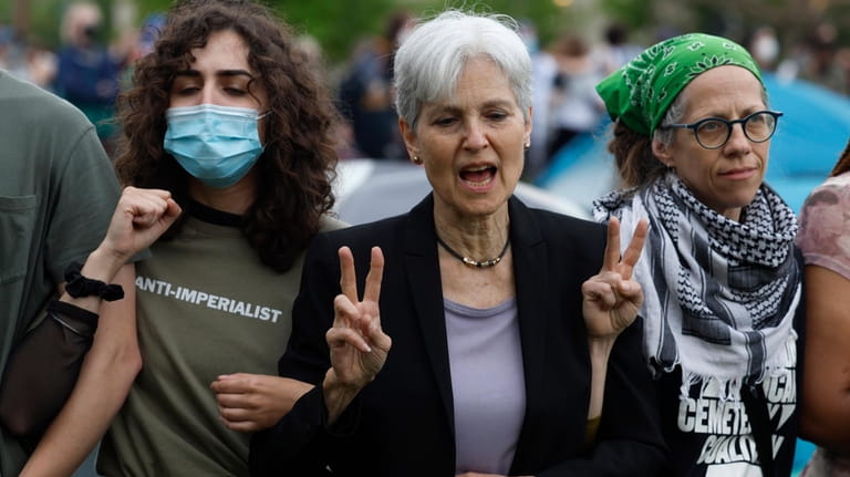 Green Party presidential candidate Jill Stein, center, links arms with...