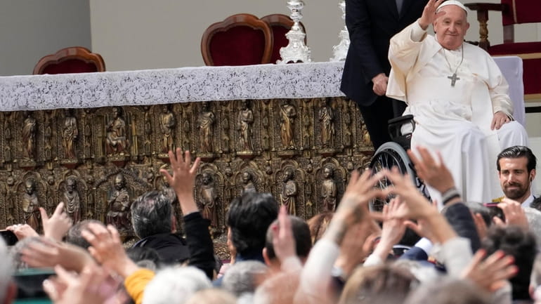 Pope Francis waves to faithful at the end of a...