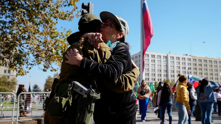 A woman embraces a Chilean police officer during a demonstration...
