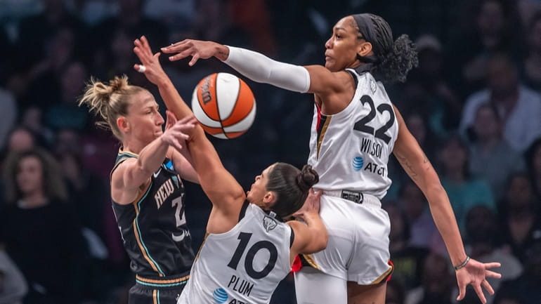 New York Liberty’s Courtney. Vandersloot passing the ball while being...