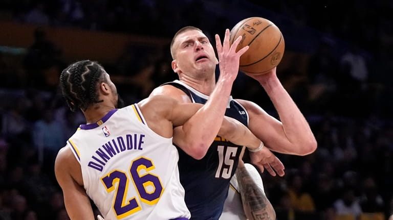 Denver Nuggets center Nikola Jokic, right, is fouled by Los...