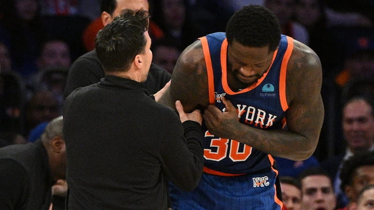 Knicks forward Julius Randle is assisted by a trainer after...