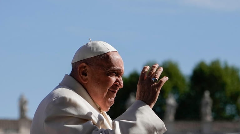 Pope Francis waves as he arrives for an audience with...