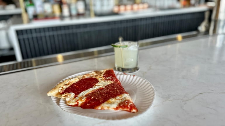 A slice of Margherita pizza is paired with a margarita...