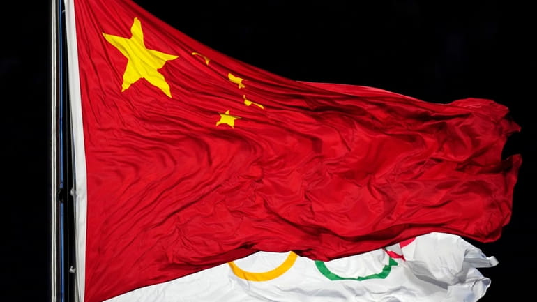 The Chinese and the Olympic flag wave during the opening...