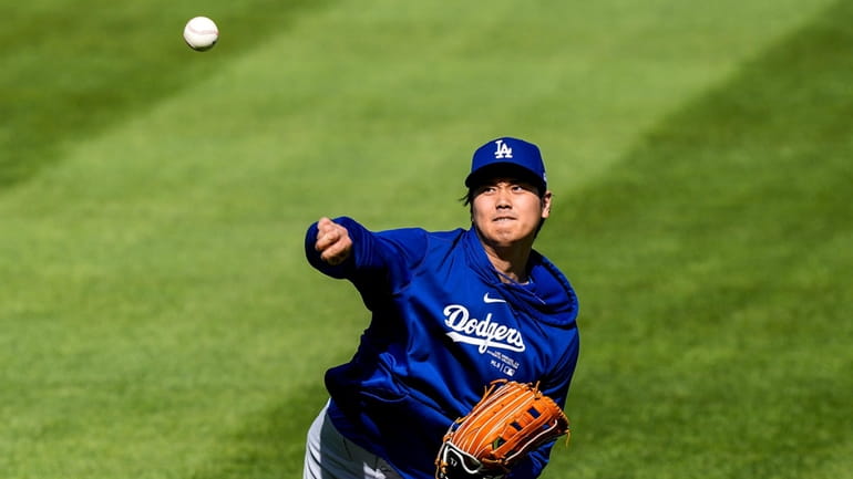 Los Angeles Dodgers' Shohei Ohtani throws before a baseball game...