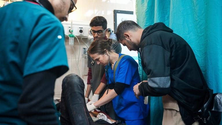 Pediatrician Tanya Haj-Hassan, center, examines wounded children at Al-Aqsa Martyrs...