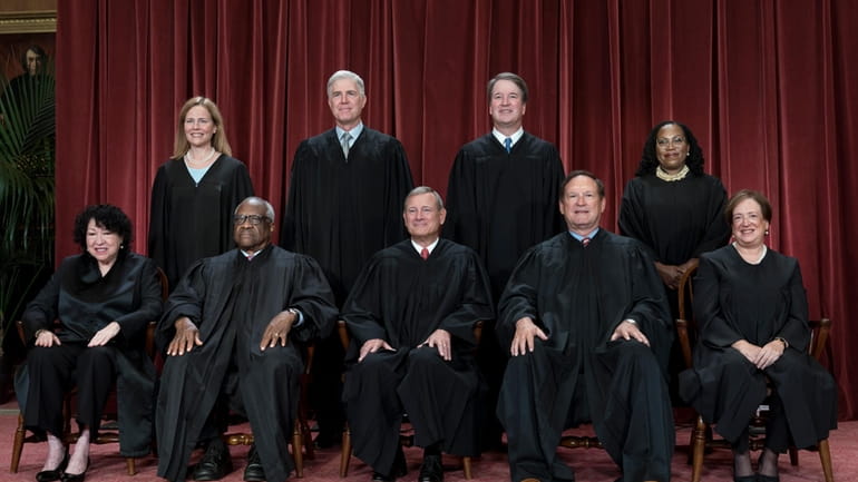 Members of the Supreme Court sit for a new group...