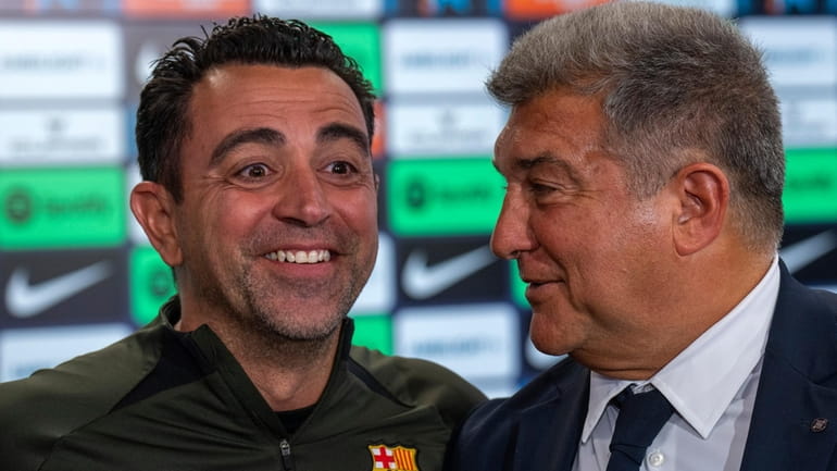Barcelona's head coach Xavi Hernandez smiles next to Barcelona's president...