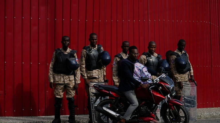 Police stand guard outside the Prime Minister's office in Port-au-Prince,...