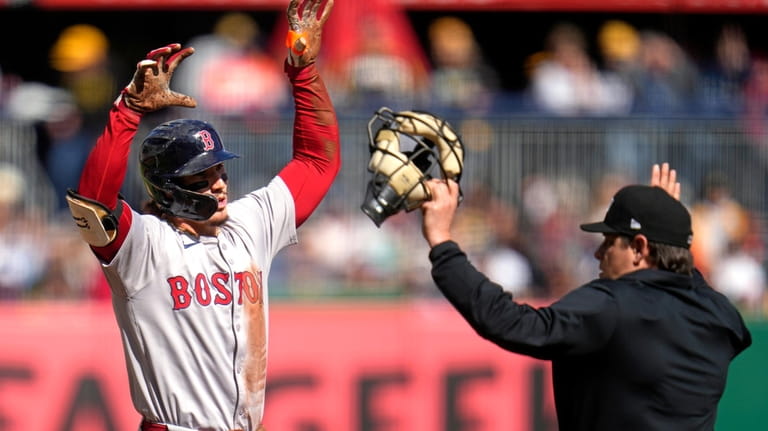 Boston Red Sox's Jarren Duran, left, celebrates after sliding safely...