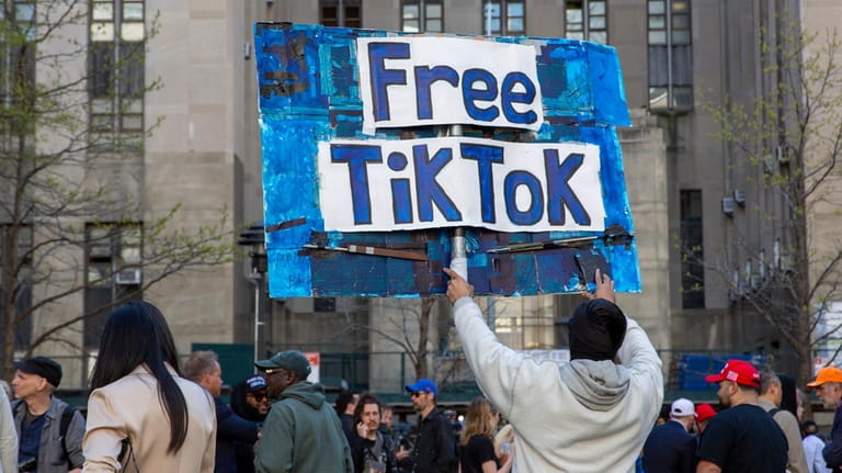 A man carries a Free TikTok sign in front of...