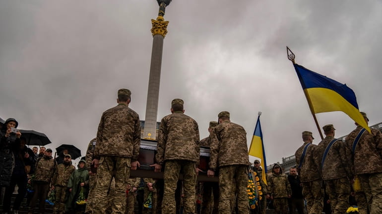 Honour guards carry the coffin of Ukrainian army paramedic Nazarii...