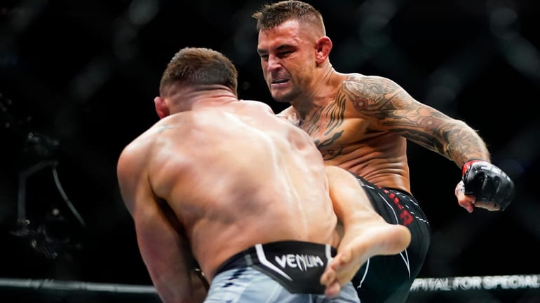 Dustin Poirier, right, kicks Michael Chandler during the first round...