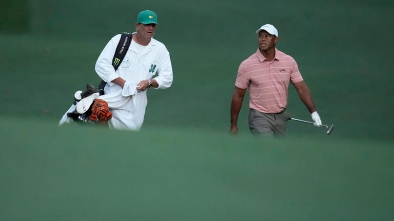 Tiger Woods walks with his caddie on the 13th hole...
