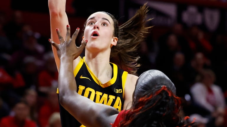 Iowa guard Caitlin Clark drives to the basket against Rutgers...