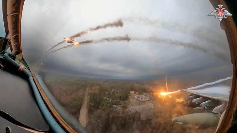 FILE – A Su-25 plane is seen firing rockets over...