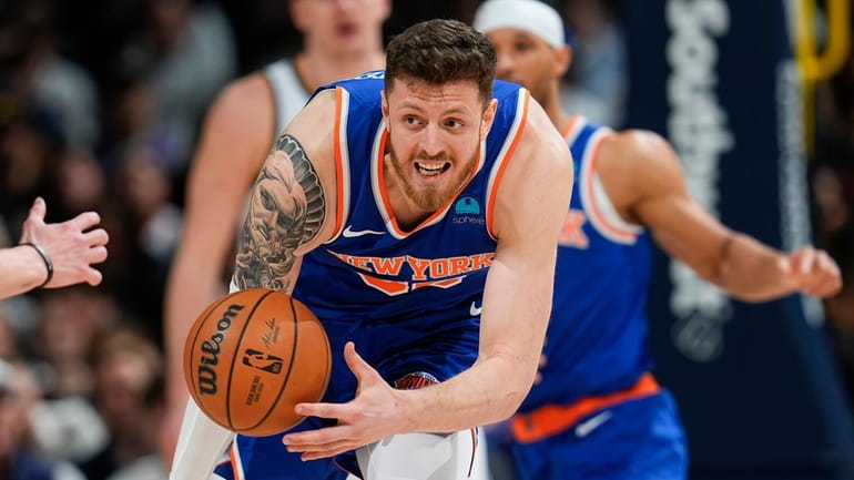 Knicks center Isaiah Hartenstein collects a loose ball before passing...