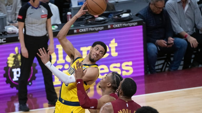 Indiana Pacers' Tyrese Haliburton, front left, looks to pass the...