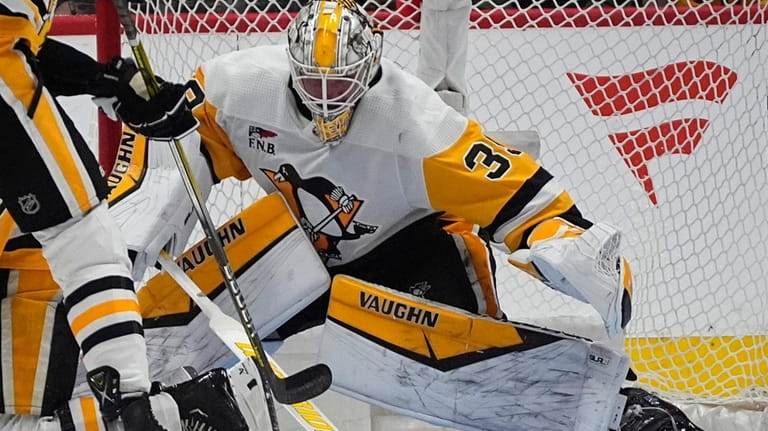Pittsburgh Penguins goaltender Alex Nedeljkovic stops a shot in the...