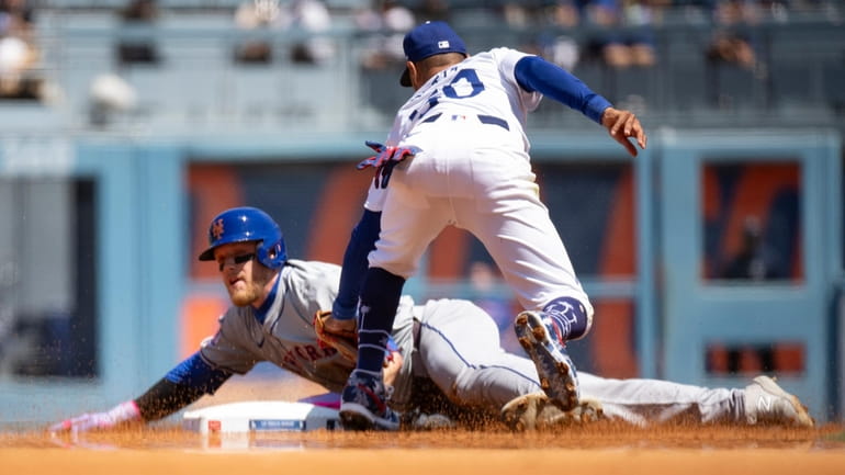 Dodgers shortstop Mookie Betts, right, tags out the Mets' Harrison...