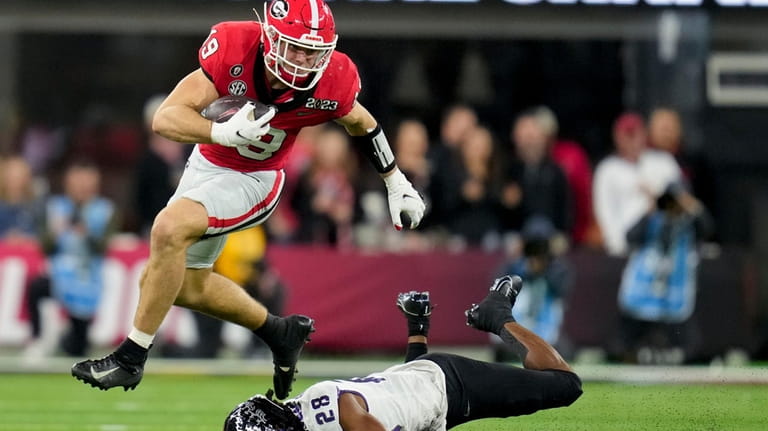 Georgia tight end Brock Bowers (19) leaps over TCU safety...