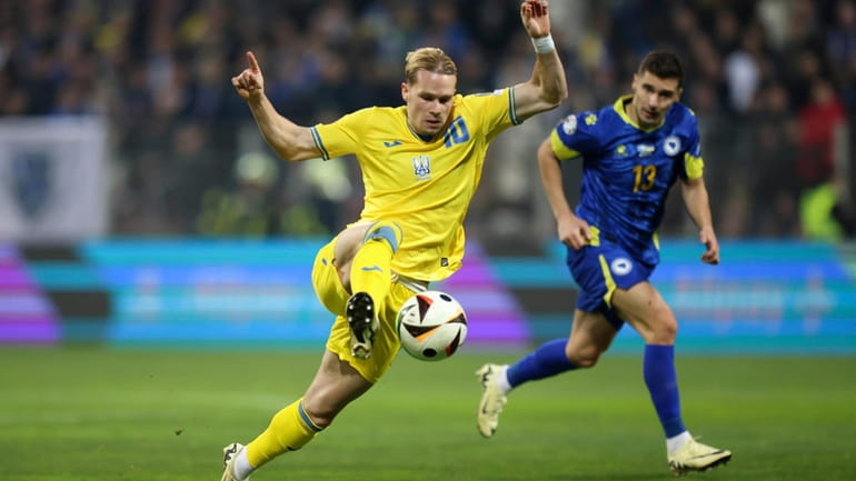 Ukraine's Mykhailo Mudryk controls the ball besides Bosnia's Gojko Cimirot...