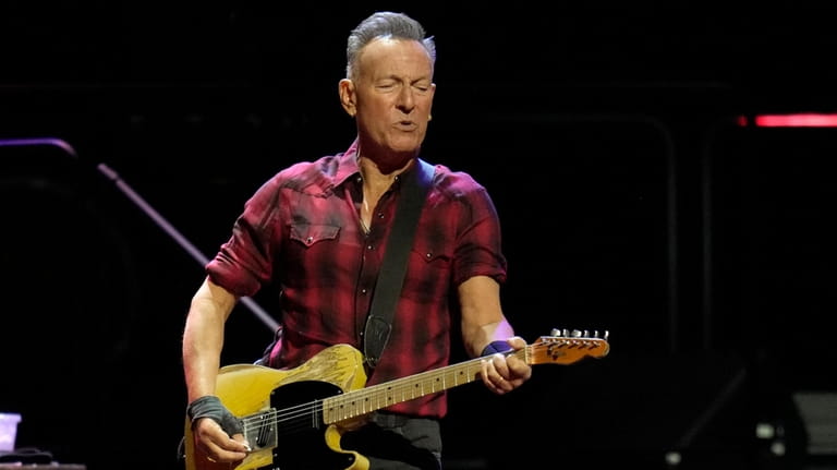 Bruce Springsteen plays his guitar on stage during his concert...