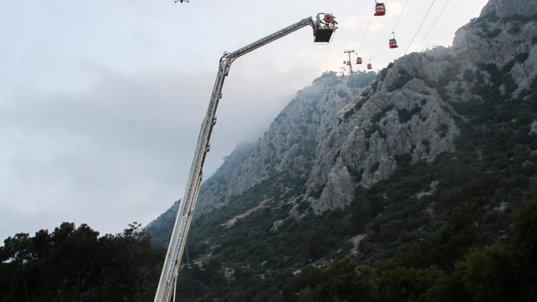 A rescue team work with passengers of a cable car...