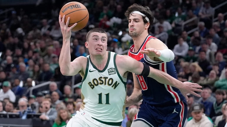 Boston Celtics guard Payton Pritchard (11) drives toward the basket...