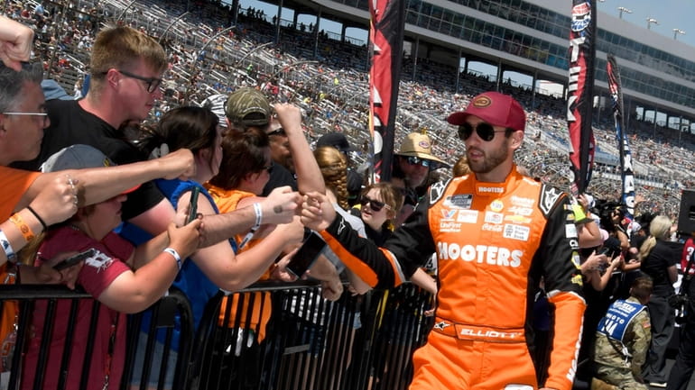 Chase Elliott, right, greets fans during driver introductions before a...