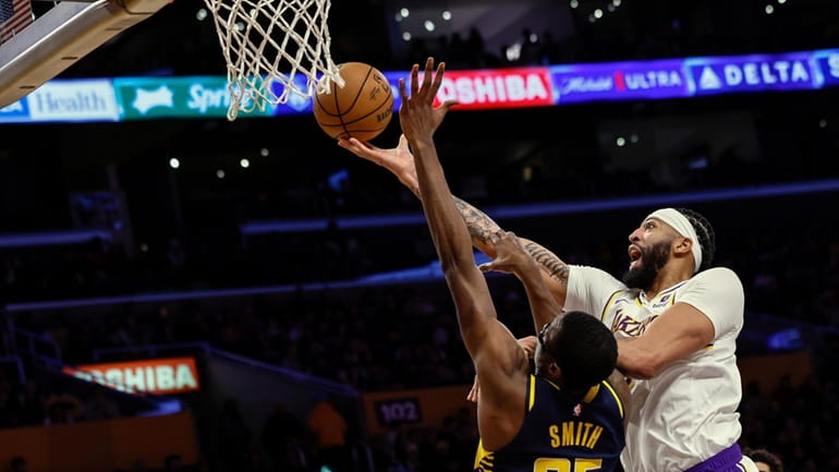 Los Angeles Lakers forward-center Anthony Davis, right, scores over Indiana...