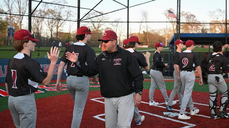 Clarke head coach Tom Abruscato is congratulated by his team on...