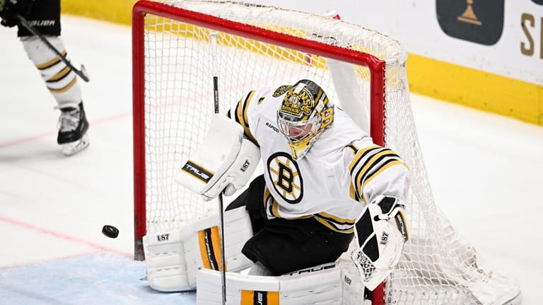 Boston Bruins goaltender Jeremy Swayman (1) defends the net during...