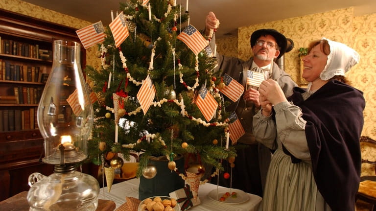 Museum interpretors decorate a civil war era Christmas tree in the...
