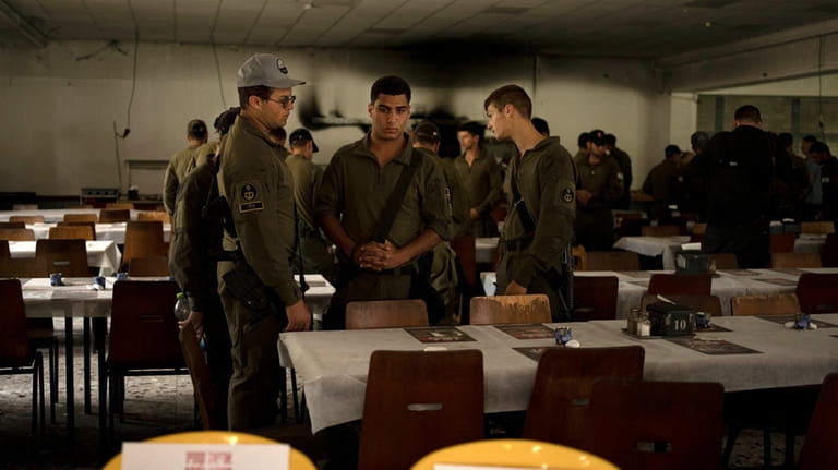 Israeli soldiers look at chairs for hostages held in Gaza...