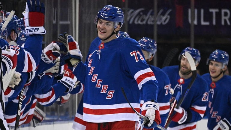 Rangers center Matt Rempe is congratulated by teammates after his...