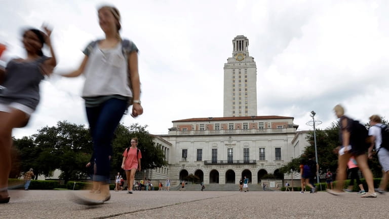 Students walk through the University of Texas at Austin campus...