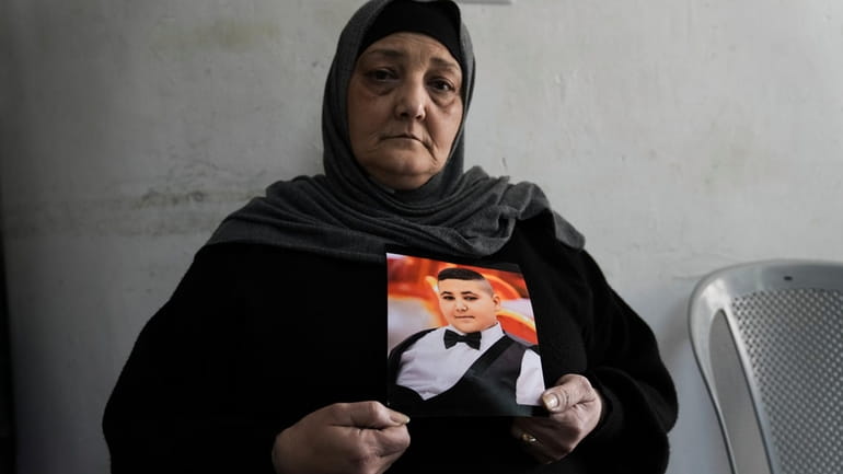 Rawiya Halhouli holds a photo of her slain son Rami...