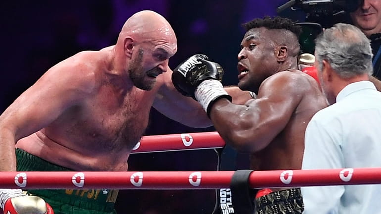 Tyson Fury, left, fights with Francis Ngannou, right, during their...