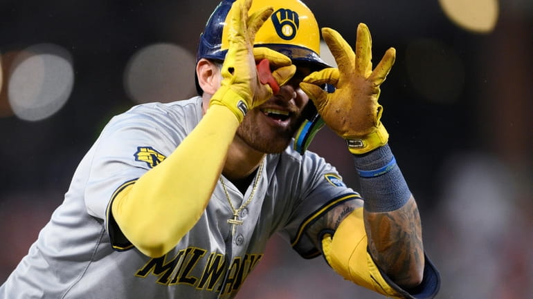 Milwaukee Brewers' Joey Ortiz gestures at third base after he...