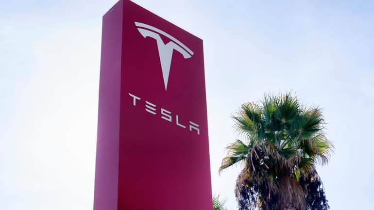 A Tesla sign is seen at a dealership, Dec. 3,...