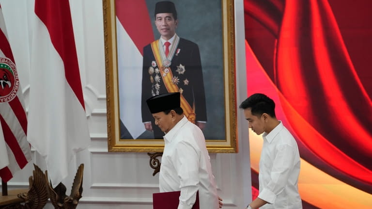 Indonesian Defense Minister and president-elect Prabowo Subianto, left, walks with...