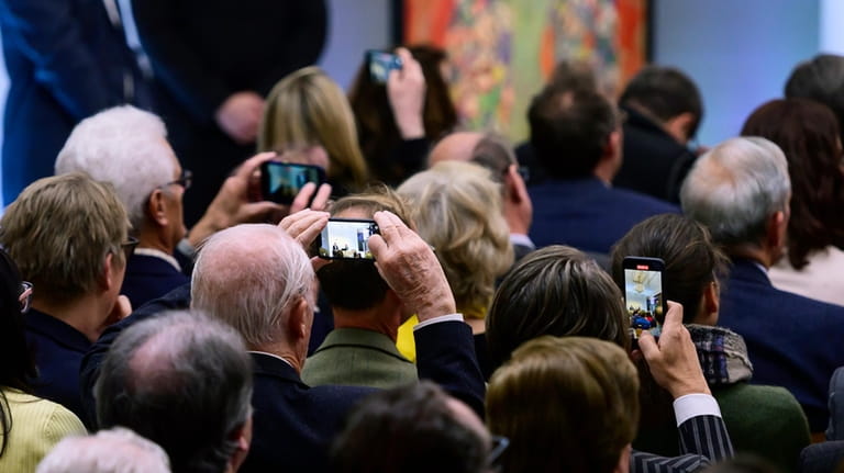 Attendees take photographs of the painting 'Portrait of Fräulein Lieser'...