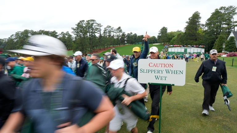 Patrons arrive for the first round during the Masters golf...