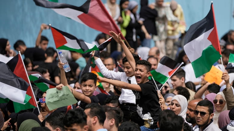 Protesters shout slogans against Israel and wave Palestinian flags at...