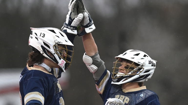 Connor Curran #13 of Bayport-Blue Point, left, gets congratulated by...