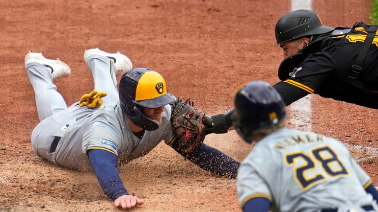 Pittsburgh Pirates catcher Joey Bart, top right, tags out Milwaukee...