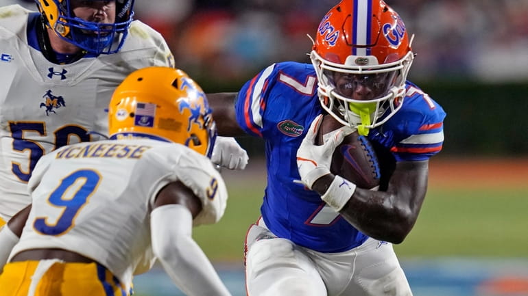 Florida running back Trevor Etienne, right, tries to get past...